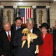 A bipartisan commission of legislators holds Buster on the Senate floor.
